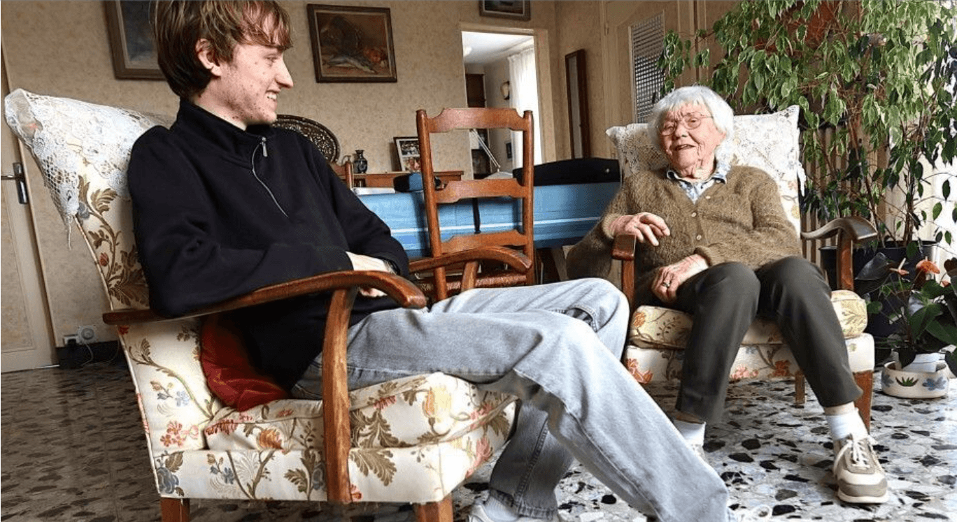 Un jeune et une sénior discutent, assis dans les fauteuils du salon.